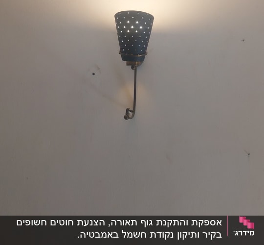 מנורת קיר דולקת עם חורים דקורטיביים